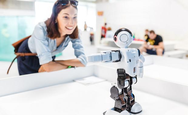 home-landing-lady-smiling-whilst-examining-robot
